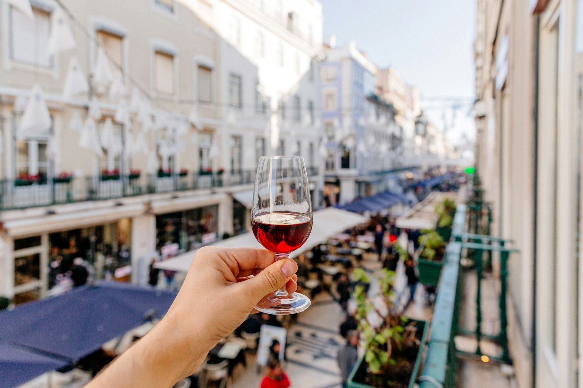 Man drinking port wine on a street in Lisbon, personal perspective view, Lisbon, Portugal
